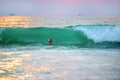 The hands of an unknown lonely floating in the beautiful ocean waves at sunset. Royalty Free Stock Photo