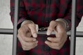 Unknown prisoner with handcuffs in the jail