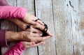 Hands of unrecognizable grandmother and her granddaughter holding rosary