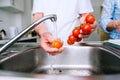 Hands of unrecognizable senior man washing tomatoes. Preparing b Royalty Free Stock Photo