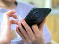 A hands of unrecognizable young caucasian woman is sitting at homeoffice tapping to smartphone`s screen Royalty Free Stock Photo