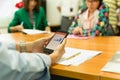 Hands using cell phone with stock money graph with group of business people. Royalty Free Stock Photo