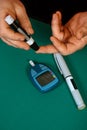 Patient measuring blood glucose using lancing device and glucometer Royalty Free Stock Photo