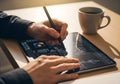 Close-up of hands drawing with stylus on tablet, remote desk setup with coffee and wood table, natural daylight lighting with Royalty Free Stock Photo