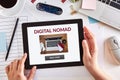 Hands using tablet with digital nomad concept on screen Royalty Free Stock Photo