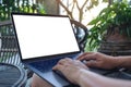 Hands using and typing on laptop with blank white desktop screen while sitting outdoor Royalty Free Stock Photo