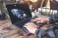 Hands using and typing on laptop touchpad on wooden table Royalty Free Stock Photo