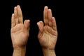 Hands in Vayu Mudra isolated on a black background. Royalty Free Stock Photo