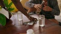 Hands of waitress serving table for a young man in tropical cafe. Waiter putting cutlery on napkin for visitor in the