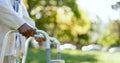 Hands, walking frame and an elderly person in a garden outdoor in summer closeup during retirement. Wellness