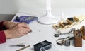 The hands of a watchmaker repairing a mechanical watch.