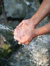 Hands, water splash and washing in nature. Man scoops up water with his hands to drink. Fresh water of mountain spring Royalty Free Stock Photo