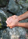 Hands, water splash and washing in nature. Man scoops up water with his hands to drink. Fresh water of mountain spring Royalty Free Stock Photo