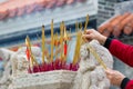 Hands Waving Smoking Incense Sticks