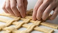 Hands Weaving Lattice Pattern with Dough for Pie Crust Royalty Free Stock Photo