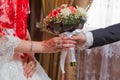 Hands with wedding flowers, groom puts on an wedding flowers to the bride, dressing up an wedding flowers, groom with Royalty Free Stock Photo