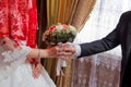 Hands with wedding flowers, groom puts on an wedding flowers to the bride, dressing up an wedding flowers, groom with Royalty Free Stock Photo