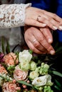 Hands with wedding gold rings happy newlyweds on a the bouquet background. Royalty Free Stock Photo