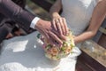 Hands with wedding rings on bridal bouquet Royalty Free Stock Photo