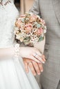 Hands with wedding rings and a flower bouquet