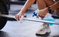 Hands, weight and covid with a gym worker spraying exercise equipment with sanitizer or disinfectant. Cleaning, bacteria