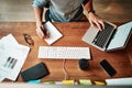 Hands that were made to work hard. Cropped high angle shot of a businessman using a laptop and writing notes at his desk Royalty Free Stock Photo