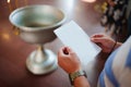 Hands with a white piece of paper in the church near the baptismal font. Royalty Free Stock Photo