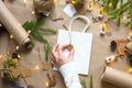 Hands in a white sweater pack a gift for Christmas and new year in eco-friendly materials: kraft paper, live fir branches, cones, Royalty Free Stock Photo