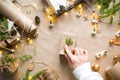 Hands in a white sweater pack a gift for Christmas and new year in eco-friendly materials: kraft paper, live fir branches, cones, Royalty Free Stock Photo