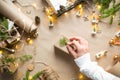 Hands in a white sweater pack a gift for Christmas and new year in eco-friendly materials: kraft paper, live fir branches, cones, Royalty Free Stock Photo