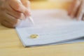 Hands of wife, husband signing decree of divorce, canceling marriage or premarital agreement prepared by lawyer