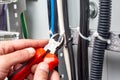 Hands with wire cutters cut the cable ties from the wires on the cable tray.Close-up. Horizontal orientation. Royalty Free Stock Photo