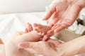 Hands of woman and baby foot, soft focus background Royalty Free Stock Photo