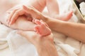 Hands of woman and baby foot, soft focus background Royalty Free Stock Photo