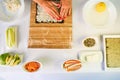 Hands of woman chef filling japanese sushi rolls with rice on a nori seaweed sheet. Royalty Free Stock Photo