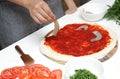 Hands of woman preparing seafood pizza with shrimps and ingredients. Process of making pizza with seafood. national cuisine.