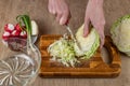 Hands of a woman chopping white cabbage with a kitchen knife on a cutting board. Preparing fresh vegan salad. Fresh Royalty Free Stock Photo
