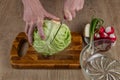 Hands of a woman chopping white cabbage with a kitchen knife on a cutting board. Preparing fresh vegan salad. Fresh vegetable Royalty Free Stock Photo