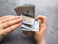 Hands of woman counting dollars on desk. Salary accrual or deferment of funds for a future purchase