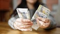 Hands of woman counting peruvian soles banknotes at room