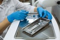 Hands woman dentist holding detail of dental tools in dental clinic.