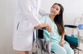 Hands woman doctor reassuring her female patient sitting on wheelchair in hospital room,Doctor giving a consultation and encourage Royalty Free Stock Photo
