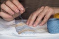 Woman`s hands embroider ornaments