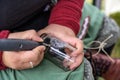 Hands of a woman engraving a decorative pattern into a glass vase from a recycled bottle at a craft market