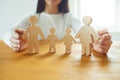 In the hands of a woman is a family of wooden figures. Family Planning Protection Concept Royalty Free Stock Photo