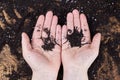 The hands of a woman farmer are holding a handful of earth