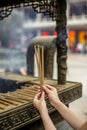 Hands of a woman holding burning incense sticks in the Jing'an temple in Shanghai Royalty Free Stock Photo