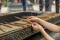 Hands of a woman holding burning incense sticks in the Jing'an temple in Shanghai Royalty Free Stock Photo
