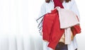 Hands Woman holding a Donate Box with full of Clothes.