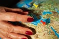 Hands of a woman holding a globe of the planet earth with marked places to travel on vacation